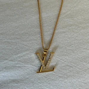 Lv halsband  - Guldfärgat stålhalsband med LV berlock. 