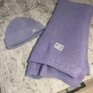 Mössa och halsduk By Malina - I ny skick, fick som julklapp. Lång stickad mohair- och ullblandad halsduk i en enkel och elegant look DETALJER • Mohair- och ullmix • By Malina Iconic patch • Bred design • 32% Mohair 28% Ull 40% Nylon • Endast kemtvätt cm	One Size Width	52 Length	2