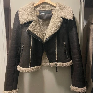 Skinnjacka - Brun skinnjacka med teddymaterial i insidan, kort passform och vida ärmar. Köpt secondhand. Storlek 38. 250kr.