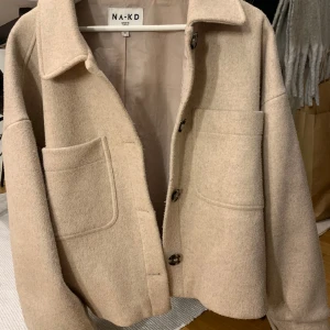 Beige kappa  - Fin beige kappa från NA-KD. Lite nopprig i tyget men annars hel och fin. 