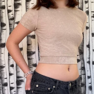 Rygglös topp - Rygglös tröja i en beige rosa färg med knytning i ryggen från Gina Tricot. Passar perfekt till både vardag som fest💕☺️ Säljer då den inte används på ett tag☺️