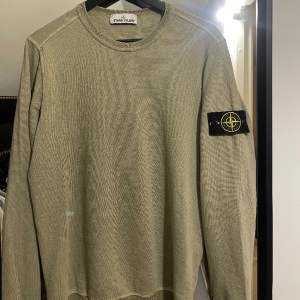 En khaki grön Stone Island sweatshirt. Storlek S men kan passa den som har M också. Köptes i Stone Island butiken i Stockholm, finns kvitto. 