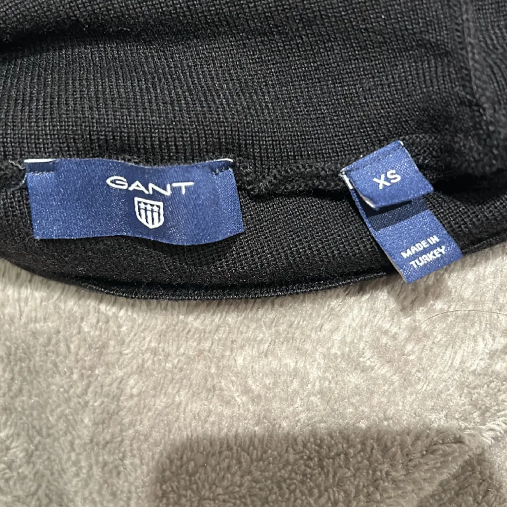 Supersnygg finstickad svart polotröja från Gant i storlek XS. Materialet är 100% ull. Har inte använt tröjan många gånger så den är i mycket fint skick. FRAKT TILLKOMMER!  Skickar ENDAST med postens blåa påsar. . Stickat.
