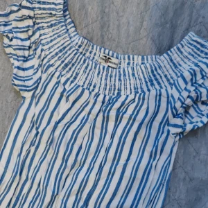 Super söt byxdress  - Super söt randig byxdress, ljusblå och vit. Perfect ingar sommaren. Dressen är för barn och köpt på barnavdelningen från Hampton Republic.