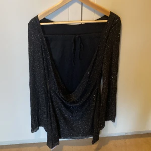 En fin glittrig festklänning med öppen rygg  - Svart klänning Storlek small skönt tyg sitter fint har bara inte kommit till användning. Super fin till utekvällar eller fest. Önskas bilder på hur den sitter bara skriv ! 