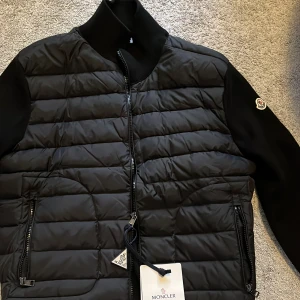 Moncler cardigan  - En helt ny och oanvänd moncler cardigan inga defekter eller någonting riktigt snygg till alla årstider och ett riktigt bra pris. Den är i storlek L men den är lite liten i storleken och passar mindre storlekar också. Skriv vid funderingar osv 👌🏽