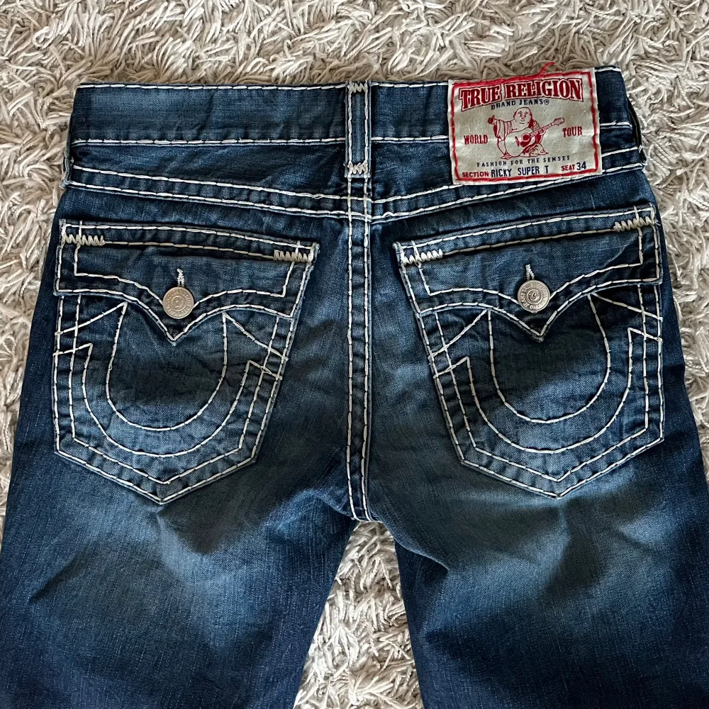Ett par ”ricky super t” true religion jeans i size 32, dope wash och bra skick bortsett från ett minimalt märke som visas på 5e bilden. 43cm midja,  75cm innerbenslängd, 21cm benöppning. Övriga funderingar hit tha DM #true. Jeans & Byxor.