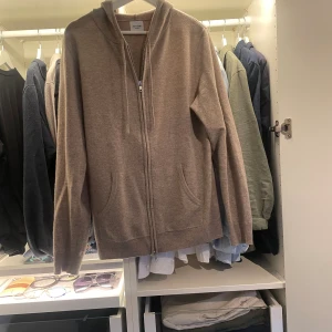100% Kashmir zip - Säljer en helt ny John Henric 100% Kashmir zip med luva, i strl medium, beige. Aldrig använd, skick 10/10. Nypris 2500 kr