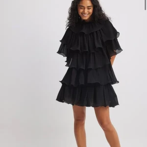 Säljer denna svarta klänning från NAKD då den var för stor för mig och jag inte hann lämna tillbaka den🖤🖤 - Miniklänning med volangdetalj. Helt slutsåld på hemsidan. Aldrig använd, bara testad. Nypris:699
