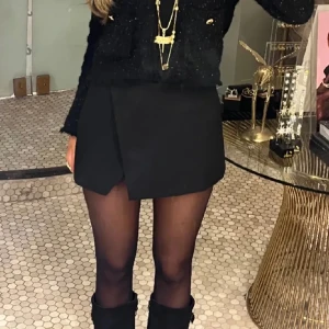 Svart kjol/shorts - Inte mina bilder! Köptes här på Plick men säljer pga för liten för mig. Super fin svart skjul men inbyggda shorts, fint skick och ser lyxig ut💕✨