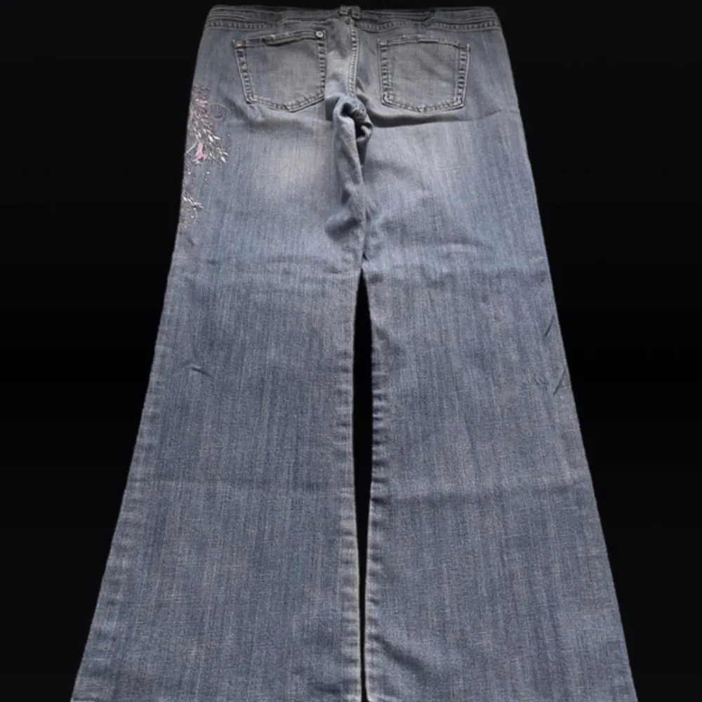 Low waist bootcut jeans med broderade blommor på sidan av benet! Super fina men inte min stil längre 💓Längd 108 cm ytterben, midja 47 cm  rakt över och benöppning 27 cm (längst ner på byxan) 💓. Jeans & Byxor.