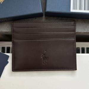 En mörkbrun ralph lauren plånbok i brunt LWG-klassat läder. Extremt bra skick, allt OG ingår. Köptes på CareOfCarl för runt 1000. Kvitto finns. 
