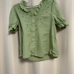 Sommartröja  - En fin t-shirt med detaljer perfekt till sommaren. Storleken är M men jag skulle mer säga en S.