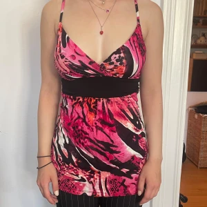 Mönstrat rosa linne - Jättefint linne! Tröjan var lite stor på modellen och det sitter en säkerhetsnål bak på ryggen. Tröjan är en liten L och en större M