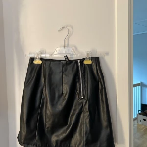 En svart skinnkjol  - En super fin kjol men tyvär aldrig kommit till användning säljer denna 100 inräknat me frakten