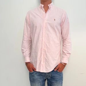 Ralph Lauren - Rosa randig Ralph Lauren skjorta i storlek 15-33 vilket motsvara ca L. Skjortan är fin men har några små lagade hål och fläckar. Modellen är 186 cm lång. Orginalpris ca 1500 kr och nu endast 299 