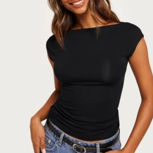 Topp - Säljer denna snygga toppen ifrån Nelly. Den är endast använd en gång och är i nyskick 