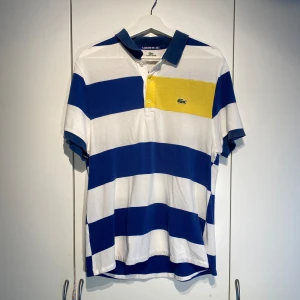 Lacoste Piké blå/vit randig  - Hej, säljer en schysst vintage pike från Lacoste i blåvit randigt mönster. Fint skick, sparsamt använd. Nypris 1200kr. Storlek Medium. Lätt att stylea och passar i alla lägen. Pris kan diskuteras. Hörs i DM!