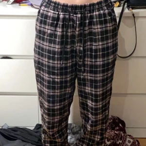 Pyjamas byxor  - Ett par svarta/rosa pyjamas byxor som har en mudd vid fötterna, ny skick 