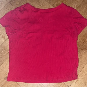Liten röd t-shirt - En cropad röd t-shirt. Frakten ingår inte i priset men priset kan diskuteras, skriv om ni har frågor🫶