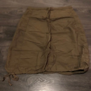 Kjol strl L - Snygg kjol med dragkedja bak, dragsko i midja och nertill och två fickor   