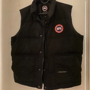 Canada goose väst  - Jag köpte denna väst till min lillebror och den kom inte till användning, han har använt den ett par gånger!! Sänker priset framförallt för att den har en skada i en av fickorna! Ord pris 7299, köpte dem för 5839kr❤️