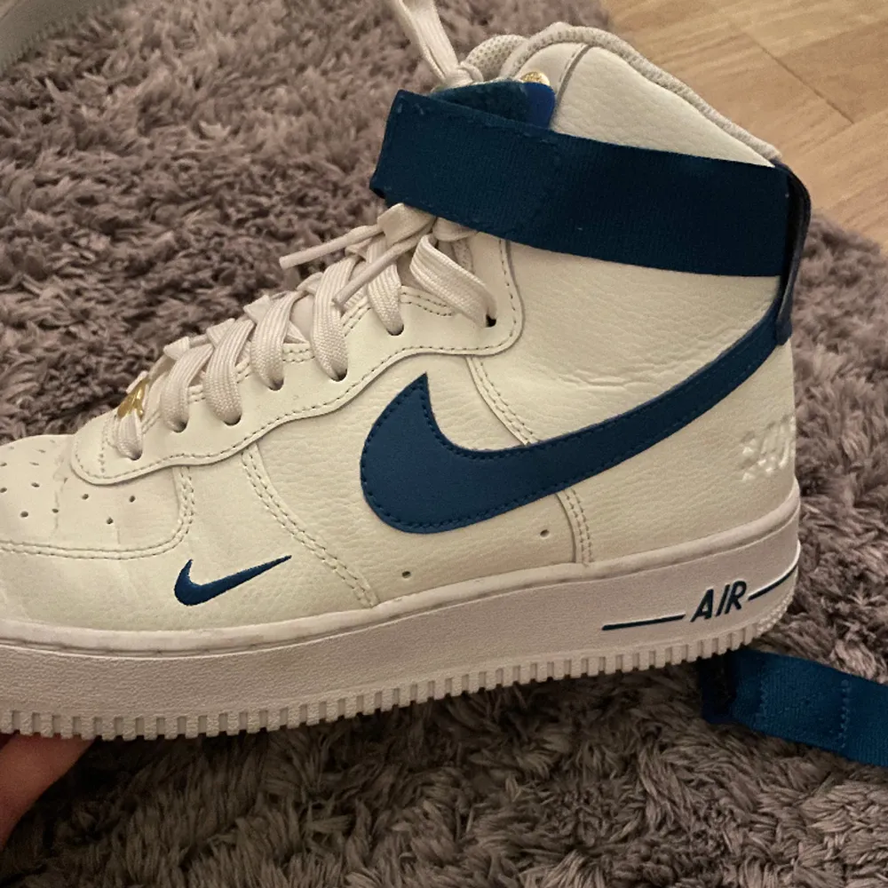 Höga Air Force 1 i storlek 40.5. Endast använda ett fåtal gånger och är i mycket bra skick, ända är lite smutsiga under sulorna så som skor blir. 8-9/10 skick! Av och påtagbara blå remmar, orginallåda medföljer. Nypris 1299 kr! Pris kan förhandlas :). Skor.