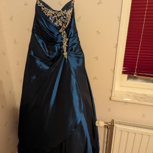 Balklänning  - Balklänning använd en gång. Fin passform, mörkblå. Strlk 42. Pris vid inköp 4800 sek. Schal inklus i priset.