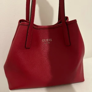 Guess väska  - Det medföljer en mindre väska som man kan knäppa in i den större. Väskan är väl omhändertagen och rymlig. Fler bilder kan skickas vid önskemål. 