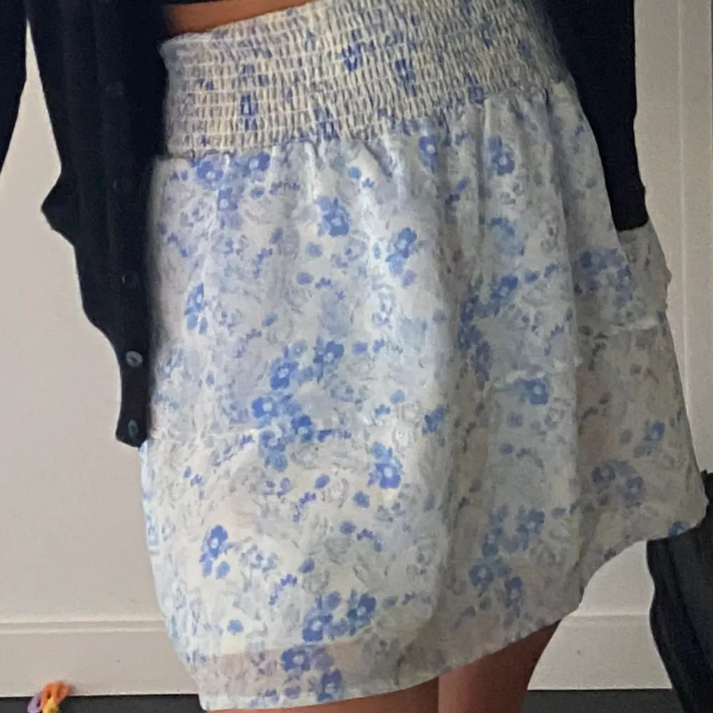 Super söt somrig kjol med blåa blommor och volang. . Kjolar.
