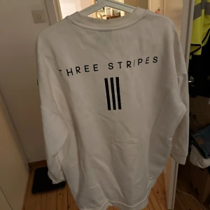 Adidas tröja - Adidas tröja i herrmodell med tryck på ryggen. 