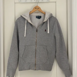 Ralph Lauren zip hoodie  - Hej, säljer en snygg Ralph Lauren zip hoodie i färgen grå samt storleken XS. Skick 8/10 sparsamt använd, annars inga problem. Kom dom för fler bilder/frågor osv!🙌🏻