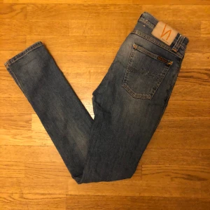 Nudie jeans - Jag säljer ett par blåa jeans från Nudie. Passformen är slimfit. Nypris på jeansen ligger på 1400 kr. Skicket på jeansen är 10/10 förutom ett litet hål i ena fickan vilket inte syns utåt. Hör gärna av er vid funderingar!