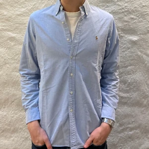 Ralph Lauren skjorta  - Ralph lauren skjorta i färgen blå. Storlek M och modellen är 186 cm. Nyskick, inga skavanker. Nypris 1699kr kr, köp för endast 599kr.