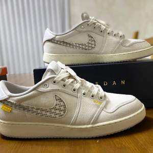 Jordan 1 Retro AJKO Low SP Union White Canvas i storlek 47,5(passar storlek 47). Originellt köpta från StockX för 2900 kr. Flera olika unika kombinationer med 3 olika alternativ på Nike loggan och 2 olika färger på snöret. *Kontakta mig för mer info*