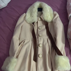 Fin ljus rosa vinter kappa från Japan - Märket är Ank Rouge. Köpte för flera år sen från Japan när jag var inne i lolita. Jätte fin ljus rosa kappa med pärlor i kragen. Har bara använt den en gång, den är superfin men inget för mig längre!  Är varm och passar fint fint till kyligare väder.