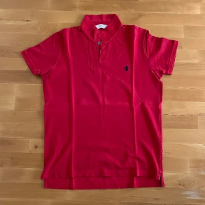 Pringle pikè röd - Röd pikè från Pringle i stl XL men sitter som en L