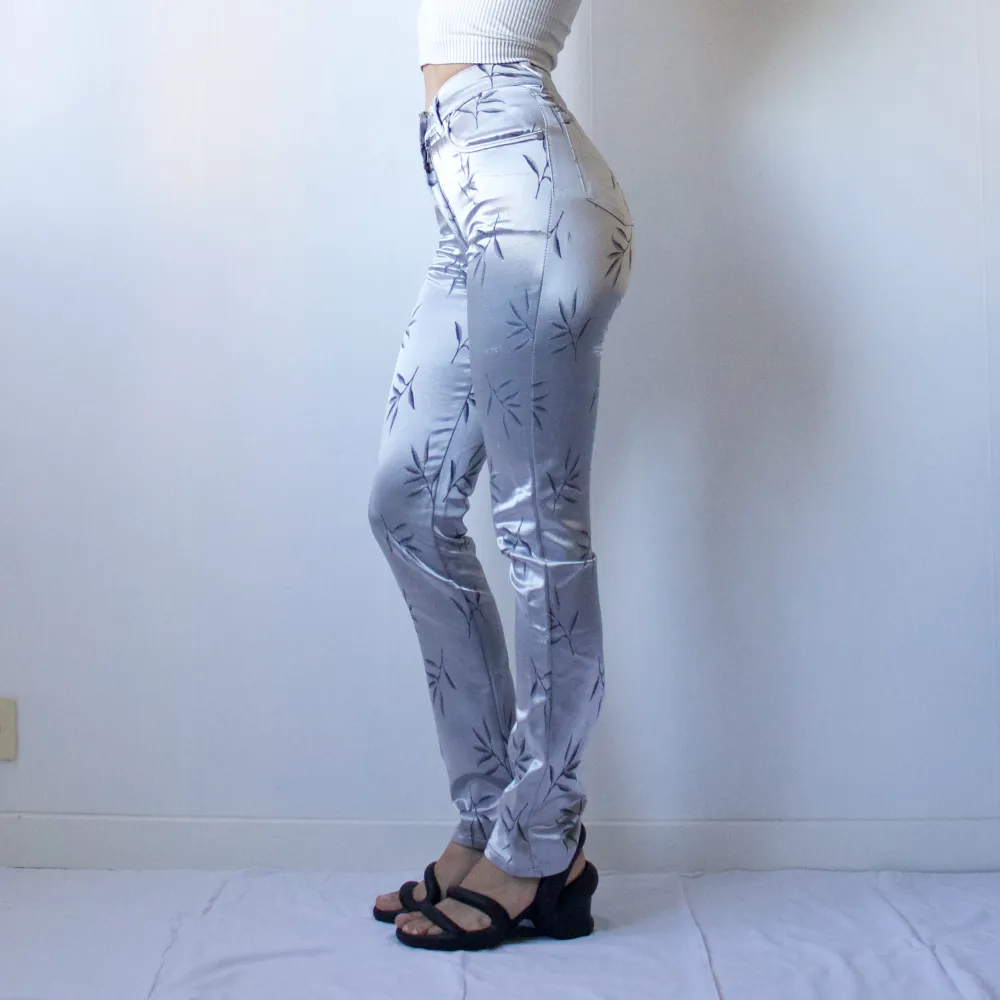 • SILKY METALLIC BLUE / SILVER SLIM HIGHWAISTED TROUSERS WITH EMBROIDERED PETAL PRINT. FABRIC HAS SOME SMALLER FLAWS/SCRATHCHES.  • SIZE - Italian 40 / EU S (Tight fit, best for XS!) • BRAND - Styker • MATERIAL - 50% acetate, 50% nylon. Jeans & Byxor.