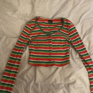 Rutig färgglad långärmad tröja. Från Gina Tricot i  storlek xxs - Jag säljer en rutten färgglad långärmad tröja med knappar och urringning.  Från Gina Tricot i storlek xx. I bra skick 
