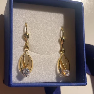 Örhängen  - Fina unika guldiga örhängen i rostfritt stål med en liten diamant liknelse längst ner. Fick dessa som en present men säljer då jag fick ett annat par. Helt nya och oanvända!⭐️ Perfekt att ge  bort som en present eller att köpa till sig själv!