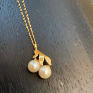 Halsbandets kedja är äkta guld i 14 karat. Pärlorna är tyvärr inte äkta. 