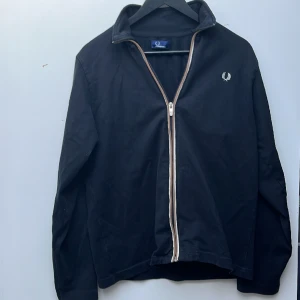Fred Perry full zip - En superfin tröja från Fred Perry. Den är i bra skick förutom att taggen sitter lite löst. Ny pris ligger på ca 1200 kr.  
