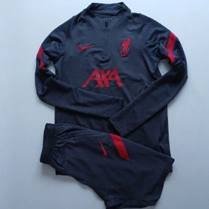 Liverpool träningställ - Liverpool träningställ.  Skick:använt ok skick,Nopprig. Byxor och tröja ingår. 158-170 ungdom XL