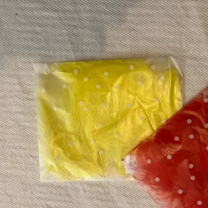 Fjädrar två paket - Två oöppnade paket med röda och gula fjädrar