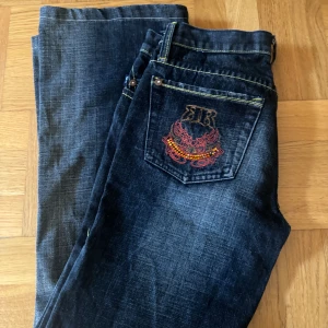 Flare jeans  - Mörkblå Flare jeans med gula sömmar och coola fickor. Mått: Midja rakt över 40cm. Innerbenslängd 70cm. Skulle säga storlek S.