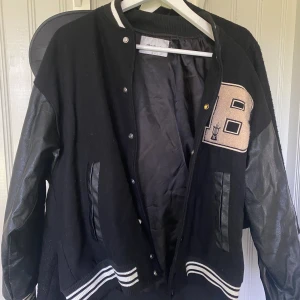 Varsity jacka - Cool varsity jacka med skinn ärmar och tryck på! Säljer för att den inte kommer till användning. Den är i storlek M men jag skulle säga att den även sitter som en overzised S! Hör gärna av er vid frågor 😊