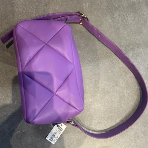 Lila handväska  - Lila handväska från Glitter. Oanvänd med taggarna kvar. Nypris 299kr