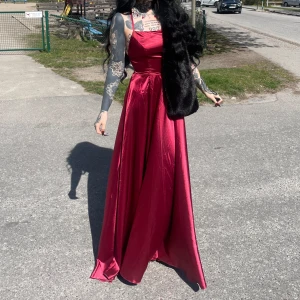 Vinröd balklänning i satin med öppen rygg - Huuuur vacker balklänning som helst med en slit och öppen rygg. Jag köpte två till min väns bröllop så den som du köper är den som jag inte har använt. Så den är i toppskick och perfekt inför student eller bal ❤️ storleken går att korrigera pga ryggen