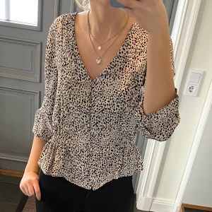 Leopardmönstrad volangblus  - Leopardmönstrad blus med knappar och volanger från JDY i storlek 36. Fint skick. Använd gärna köp nu!