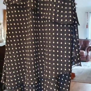 Vacker klänning med volanger - En jätte söt klänning från KappAhl storlek 36 figursydd med fina volanger svart med vita prickar dragkedja i midjan ..härlig sommar  klänning ..OBS fler bilder kan fås!!!